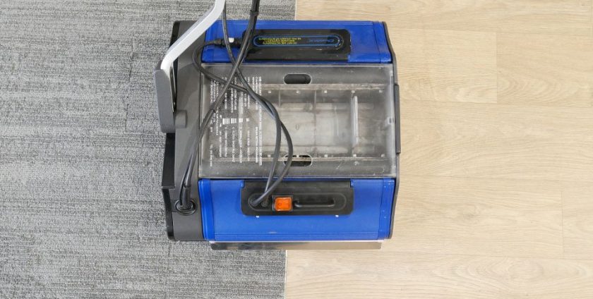 All-purpose floor scrubber machine in action on hard flooring and grey carpet, capturing mid-cleaning results.